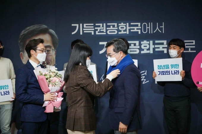 미래당 당직자가 김 후보에게 미래당의 상징색 파란 목도리를 해주고 있다. <사진=새로운물결>