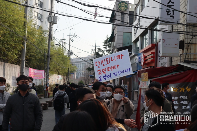 한 대진연 회원이 국민의힘을 비판하는 피켓을 들고 삿대질을 하고 있다. <사진=윤동욱 기자>