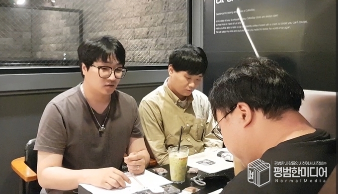 왼쪽부터 시계 방향으로 박효영 기자, 정회민 크루, 윤동욱 기자가 공약집과 특집 기사를 읽으며 대화를 하고 있는 모습. <사진=박효영 기자>